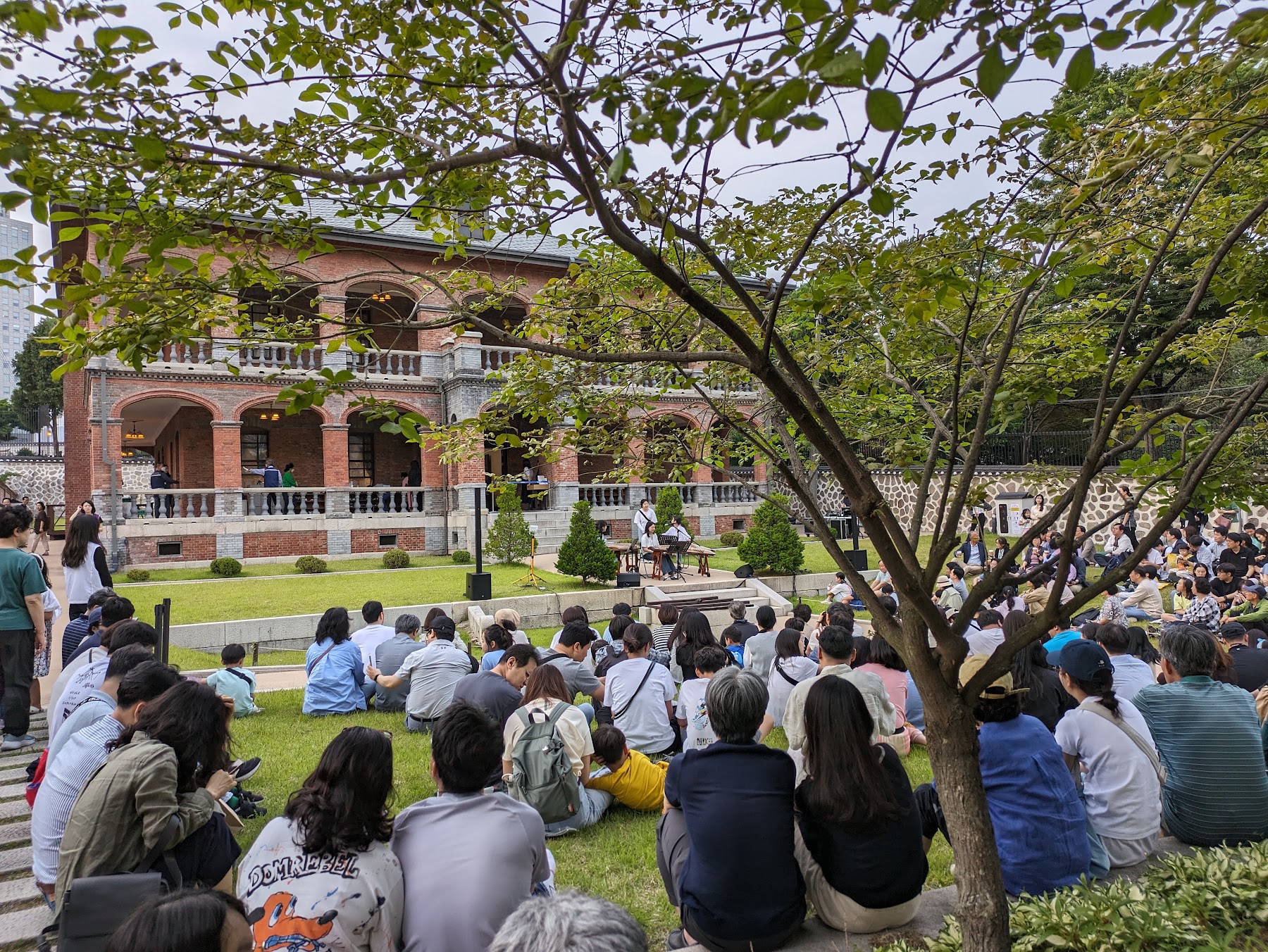 People gathered on a lawn for an outdoor event in Seoul