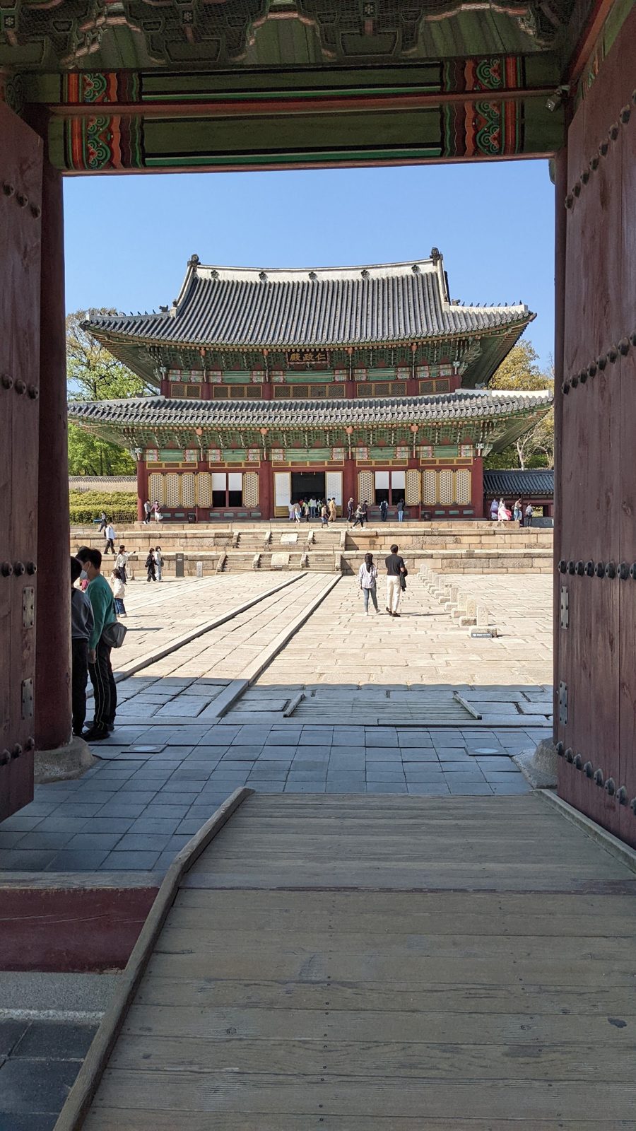 A palace hall seen through an open wooden gate