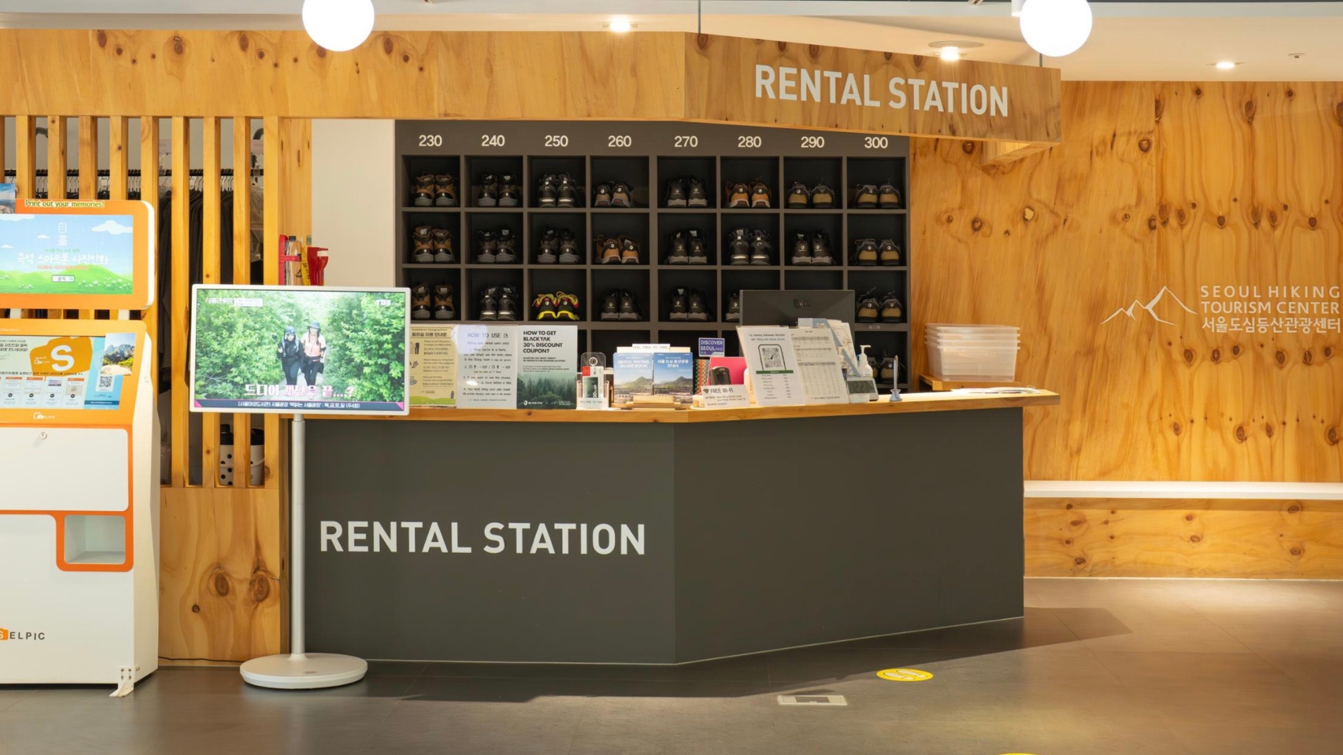 The rental station inside the Seoul Hiking Tourism Center, with hiking boots shelved by size and jackets hanging behind the counter